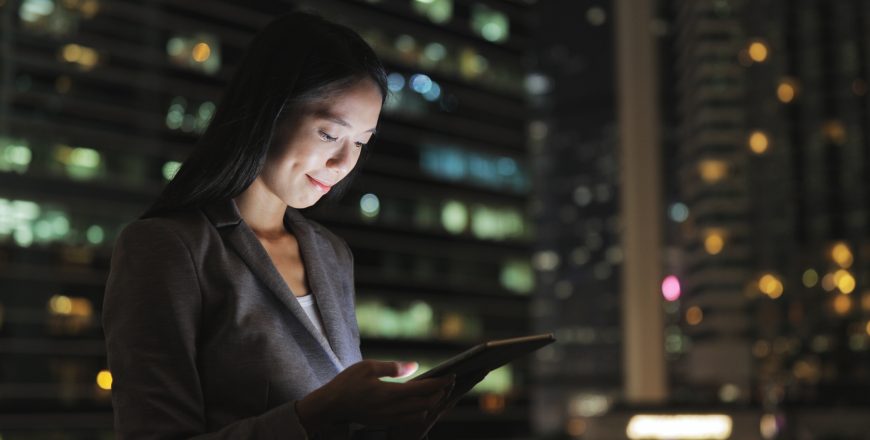 Businesswoman using digital tablet at night